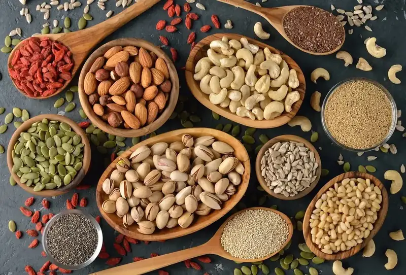 Nuts, seeds and dried fruit in wooden bowls